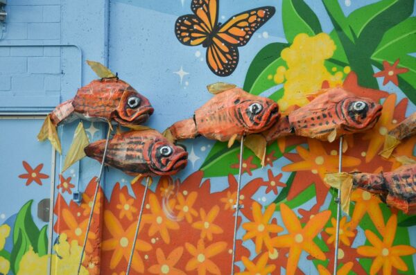Fish puppets by artist Mark Safford sitting backstage. BareBones Extravaganza 2022. Photo Lucy Moroukian.