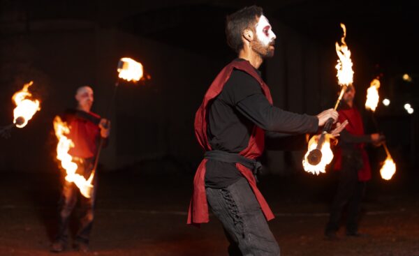 Fire Coordinator and twirler, Nat Allister, during a performance. BareBones Extravaganza 2022. Photo by Paul Irmiter.