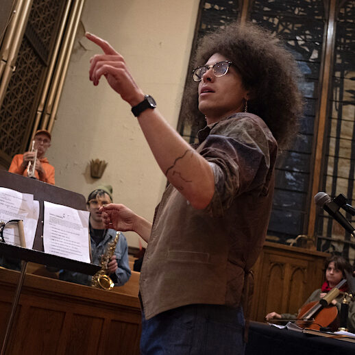 A person directing an orchestra in a rehearsal.