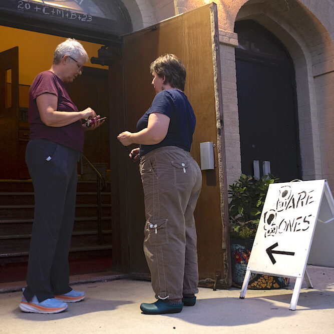 A person welcoming a BareBones volunteer into a build space.